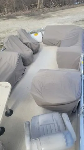 Slide: The Image of 2000 Godfrey Pontoons San Pan with covered seating, parked on a sandy shore. - 13