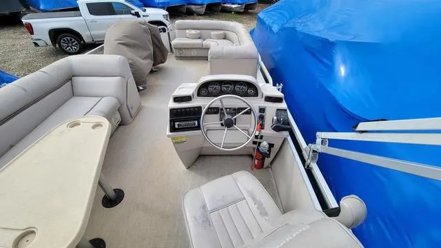 Slide: The Image of 2000 Godfrey Pontoons San Pan interior with steering wheel and seating. - 5
