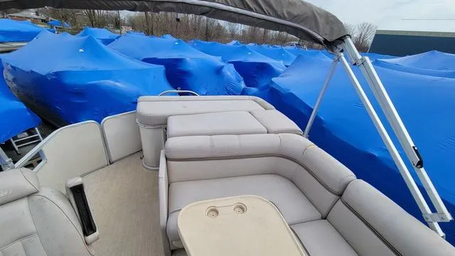 Slide: The Image of 2000 Godfrey Pontoons San Pan interior with blue-covered boats in the background. - 9