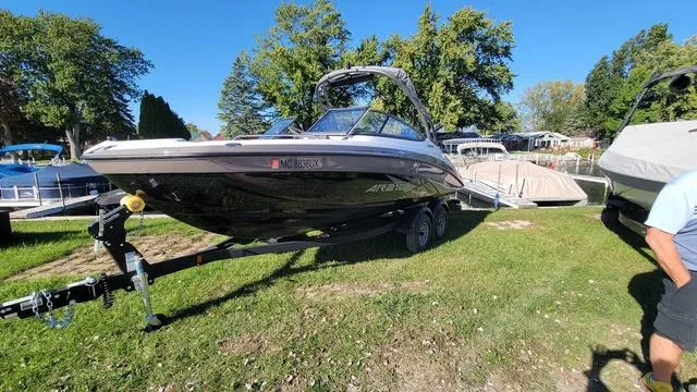 Slide: The Image of 2022 Yamaha AR210 boat on trailer, parked on grass near dock, under clear blue sky. - 1