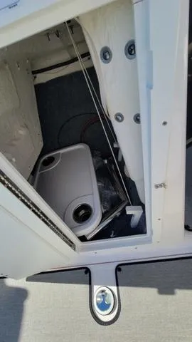Slide: The Image of 2022 Yamaha Boats AR210 storage compartment with hatch open, showcasing interior details. - 11