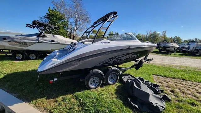 Slide: The Image of 2022 Yamaha AR210 boat on trailer, parked on grass, with clear blue sky. - 4