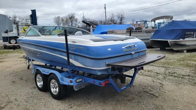 Slide: The Image of 2004 MasterCraft MariStar 210 boat on trailer, blue and white, parked outdoors. - 2