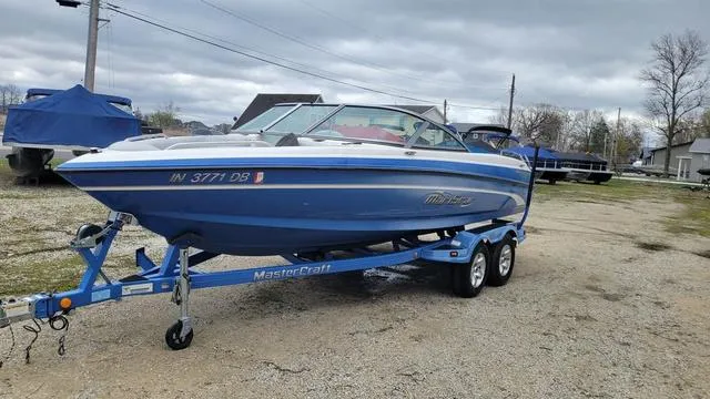 Slide: The Image of 2004 MasterCraft MariStar 210 boat on trailer, blue and white, parked outdoors. - 6