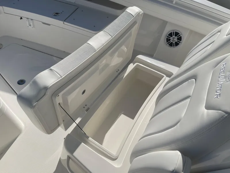 Slide: The Image of 2022 Regulator 28 boat interior with open storage compartment and cushioned seating. - 11