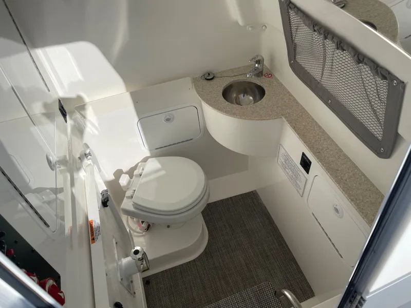 Slide: The Image of 2022 Regulator 28 boat interior with toilet, sink, and storage compartments. - 12
