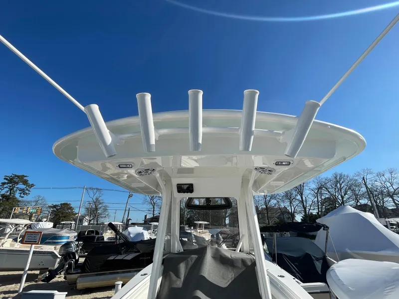Slide: The Image of 2022 Regulator 28 boat with T-top and rod holders under clear blue sky. - 21