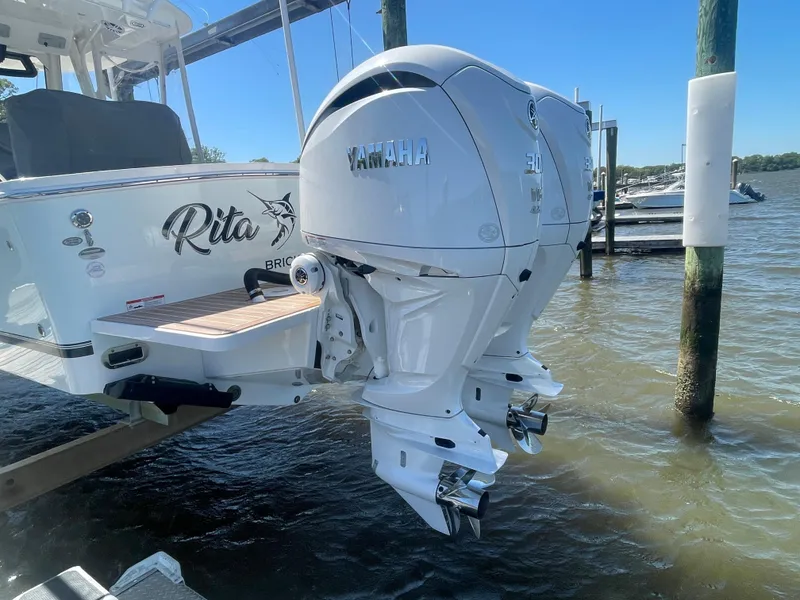 Slide: The Image of 2022 Regulator 28 boat with dual Yamaha outboard engines, docked by the water. - 24