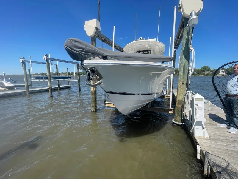Slide: The Image of 2022 Regulator 28 boat docked on a lift, clear blue sky background. - 29