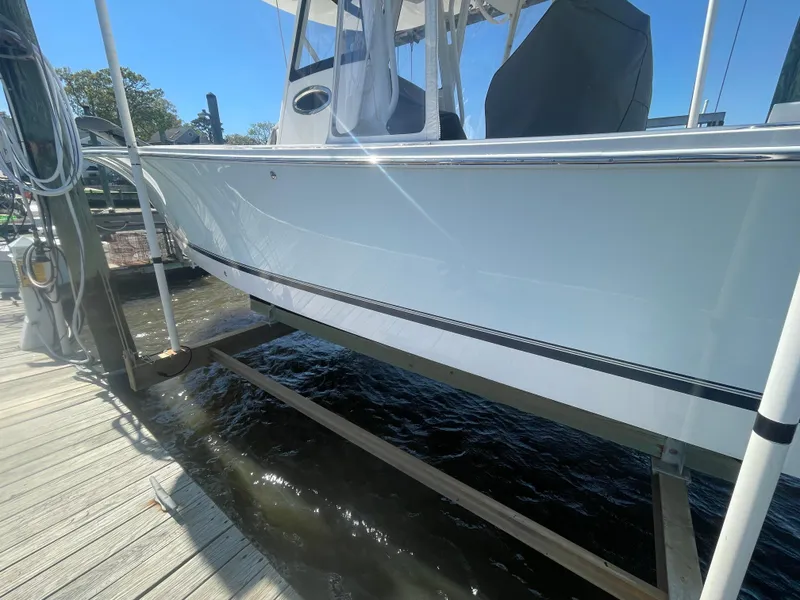 Slide: The Image of 2022 Regulator 28 boat docked, side view with clear blue sky. - 30