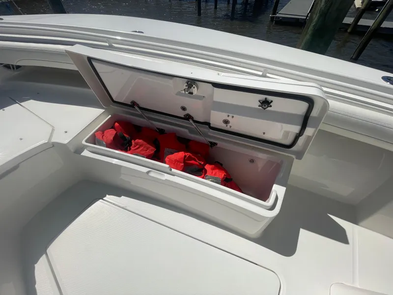 Slide: The Image of Storage compartment on 2022 Regulator 28 boat with red life jackets inside. - 31