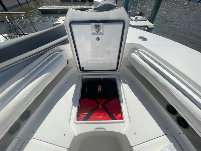Slide: The Image of 2022 Regulator 28 boat with open storage compartment, docked by the water. - 32
