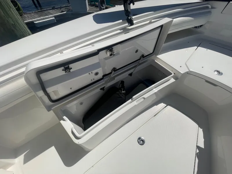 Slide: The Image of 2022 Regulator 28 boat storage compartment open, showcasing spacious interior design. - 34
