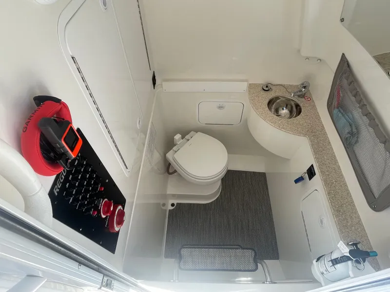 Slide: The Image of 2022 Regulator 28 boat interior with toilet, sink, and control panel. - 43