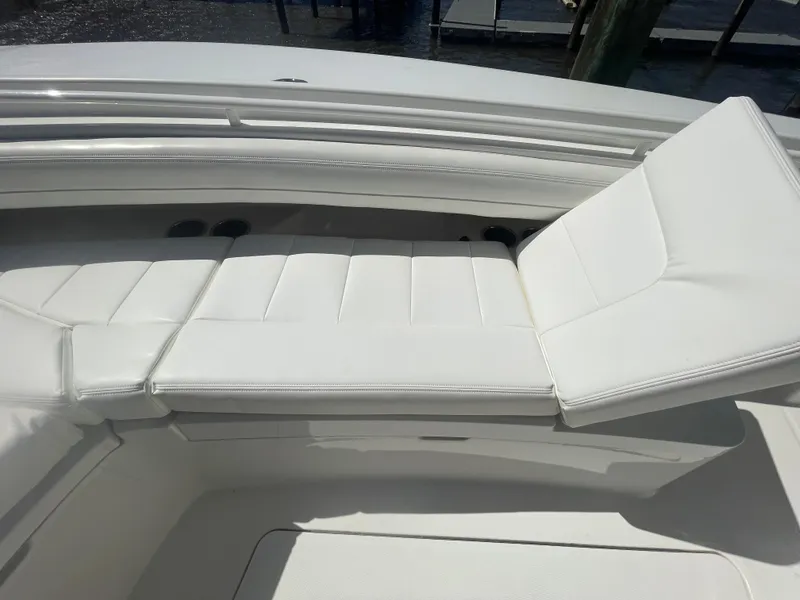 Slide: The Image of 2022 Regulator 28 boat with white cushioned seating in sunlight. - 49