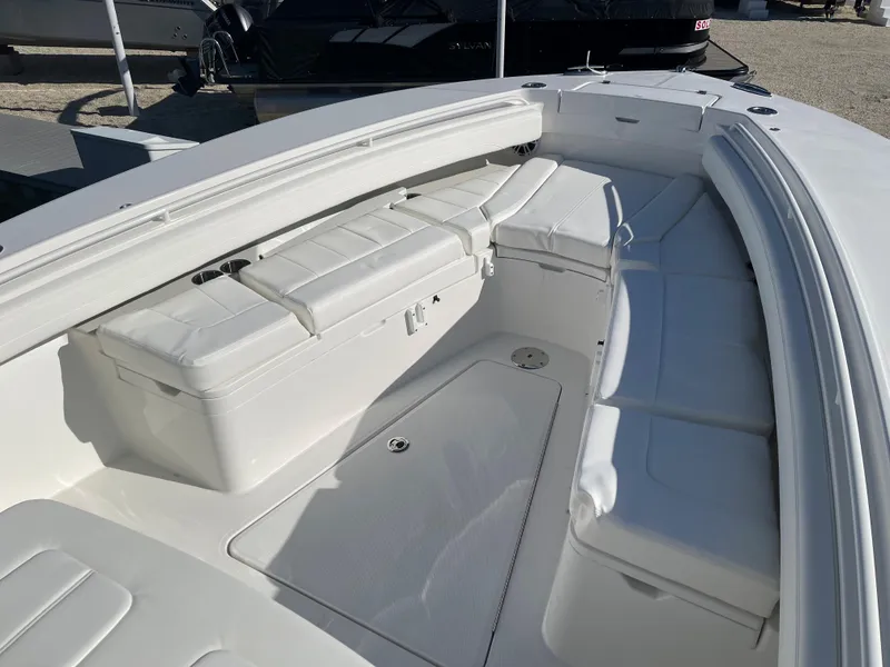Slide: The Image of 2022 Regulator 28 boat interior with white cushioned seating and storage compartments. - 5
