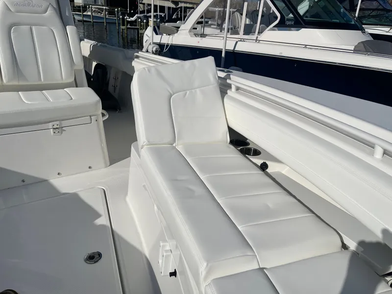 Slide: The Image of 2022 Regulator 28 boat with white cushioned seating and sleek design. - 6