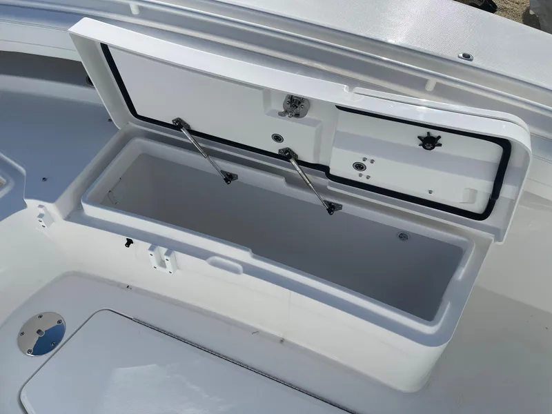 Slide: The Image of Open storage compartment on 2022 Regulator 28 boat, featuring secure latches and hydraulic supports. - 9