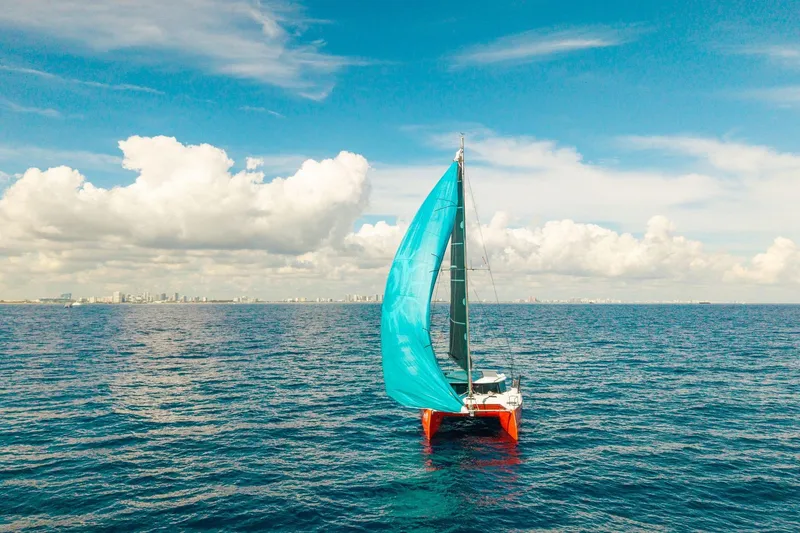 Slide: The Image of Sailboat Balance 482, 2021 model, with blue sail on open ocean under clear sky. - 165