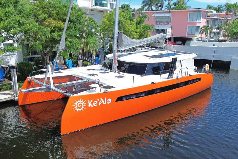 Slide: The Image of Sailing catamaran Balance 482, 2021 model, with vibrant blue sails on open ocean. - 2