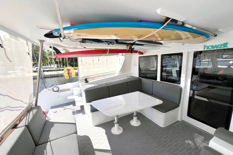 Slide: The Image of Luxurious 2021 Balance 482 yacht interior with waterfront view, featuring seating and surfboards. - 24