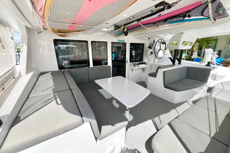 Slide: The Image of Luxurious 2021 Balance 482 yacht interior with surfboards, overlooking serene waterfront and palm trees. - 25