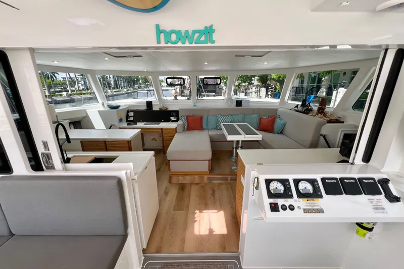 Slide: The Image of Interior of 2021 Balance 482 catamaran with modern seating and surfboard decor. - 37