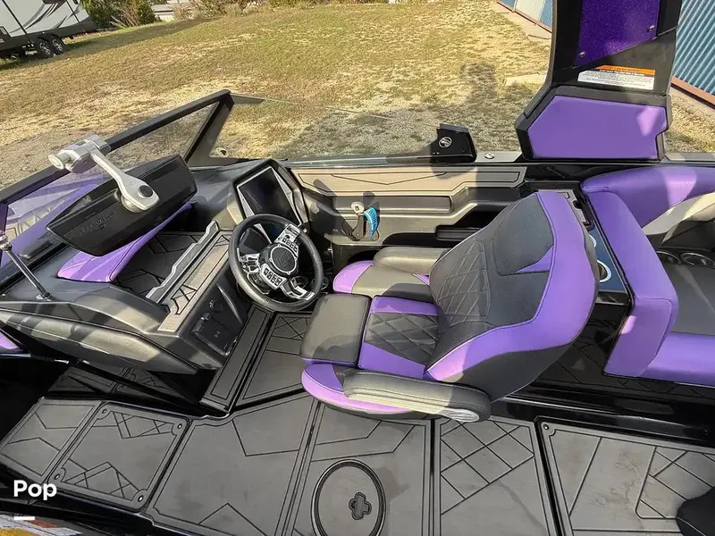 Slide: The Image of 2022 Tigé Z3 boat interior with purple and gray seating, modern dashboard, and steering wheel. - 10