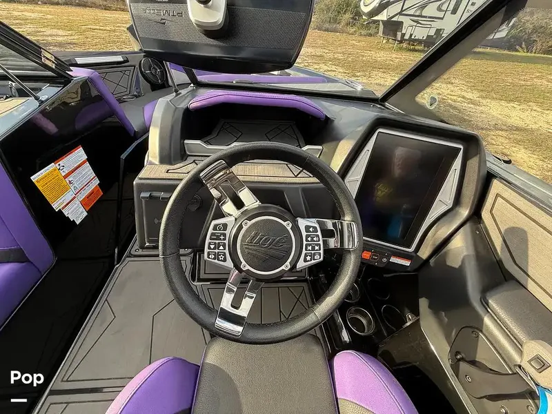 Slide: The Image of 2022 Tigé Z3 boat interior with modern steering wheel and touchscreen display. - 11