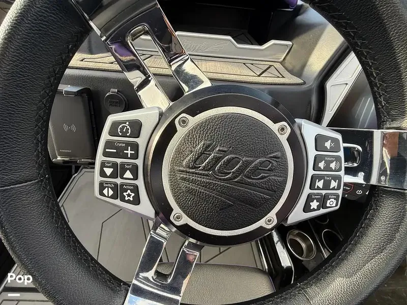 Slide: The Image of Steering wheel of a 2022 Tigé Z3 boat with control buttons and chrome accents. - 13