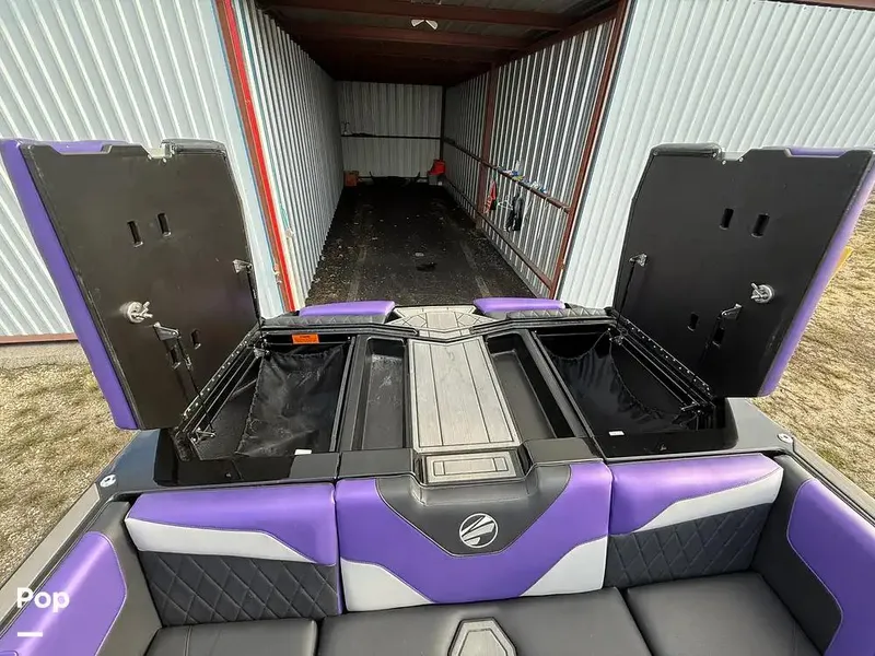 Slide: The Image of 2022 Tigé Z3 boat with purple and black interior, open storage compartments, in a metal storage unit. - 14