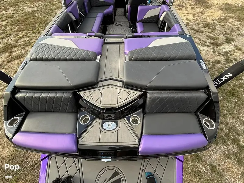 Slide: The Image of 2022 Tigé Z3 boat interior with purple and black seating, diamond stitching, and cup holders. - 5