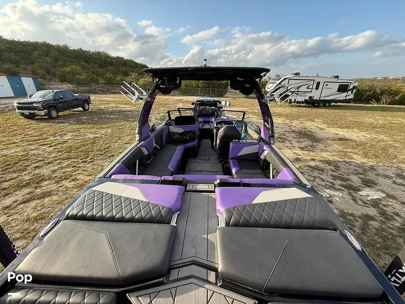 Slide: The Image of 2022 Tigé Z3 boat with purple and black interior, parked outdoors. - 6