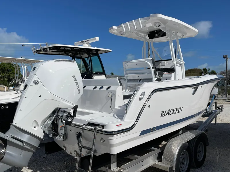 Slide: The Image of 2025 Blackfin 222CC boat on trailer, featuring a powerful outboard motor. - 2