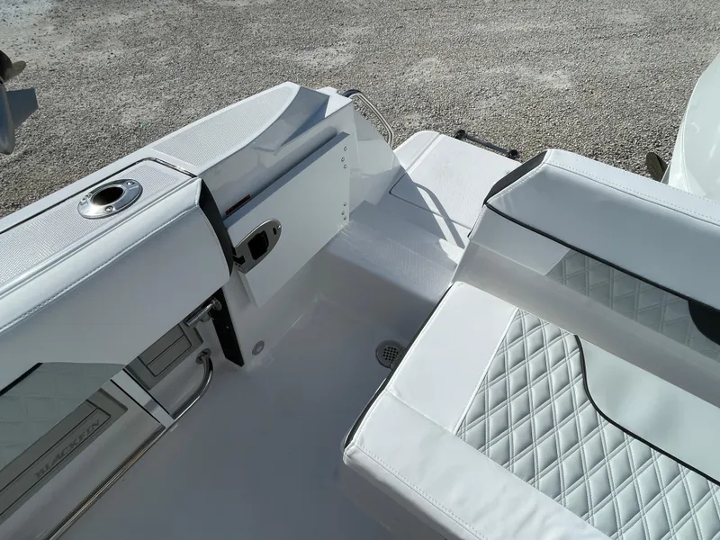 Slide: The Image of 2025 Blackfin 222CC boat interior with white cushioned seating and storage compartments. - 21