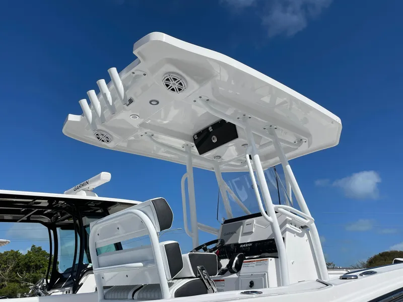 Slide: The Image of 2025 Blackfin 222CC boat with T-top and seating, under clear blue sky. - 5