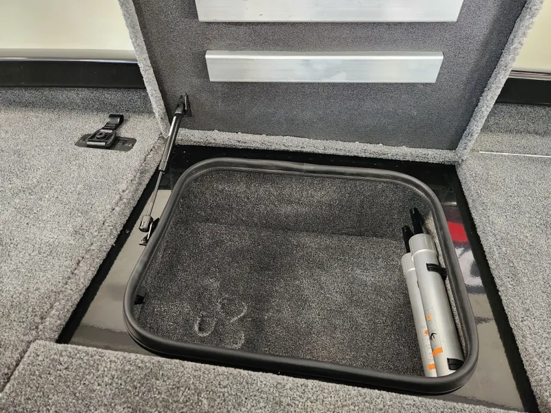 Slide: The Image of Open storage compartment in 2025 Ranger RT198P boat, featuring carpeted interior and hydraulic lift. - 11