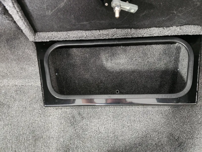 Slide: The Image of 2025 Ranger RT198P boat storage compartment with carpeted interior and black trim. - 12