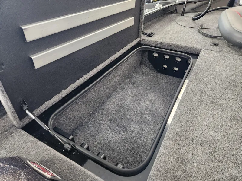 Slide: The Image of Open storage compartment in 2025 Ranger RT198P boat, featuring carpeted interior. - 13