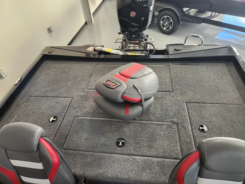 Slide: The Image of 2025 Ranger RT198P boat interior with gray and red seating, carpeted deck, and motor. - 16