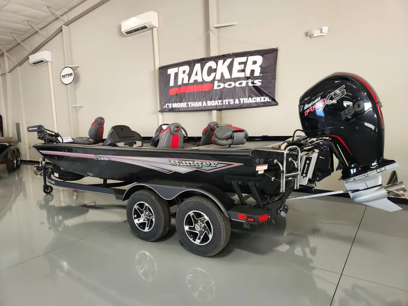 Slide: The Image of 2025 Ranger RT198P bass boat in showroom, featuring sleek design and powerful outboard motor. - 2