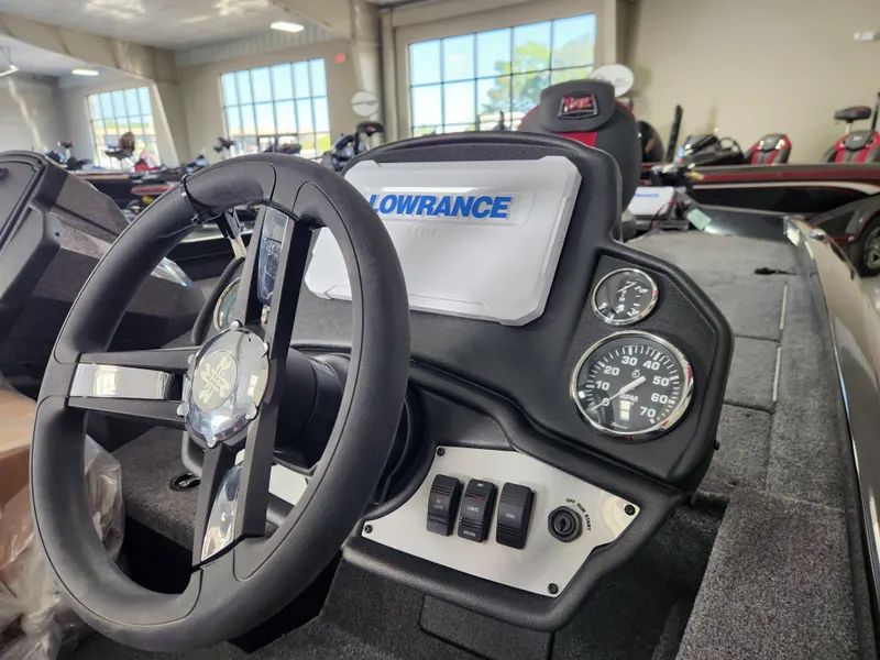 Slide: The Image of 2025 Ranger RT198P boat dashboard with steering wheel, Lowrance display, and gauges in showroom. - 6