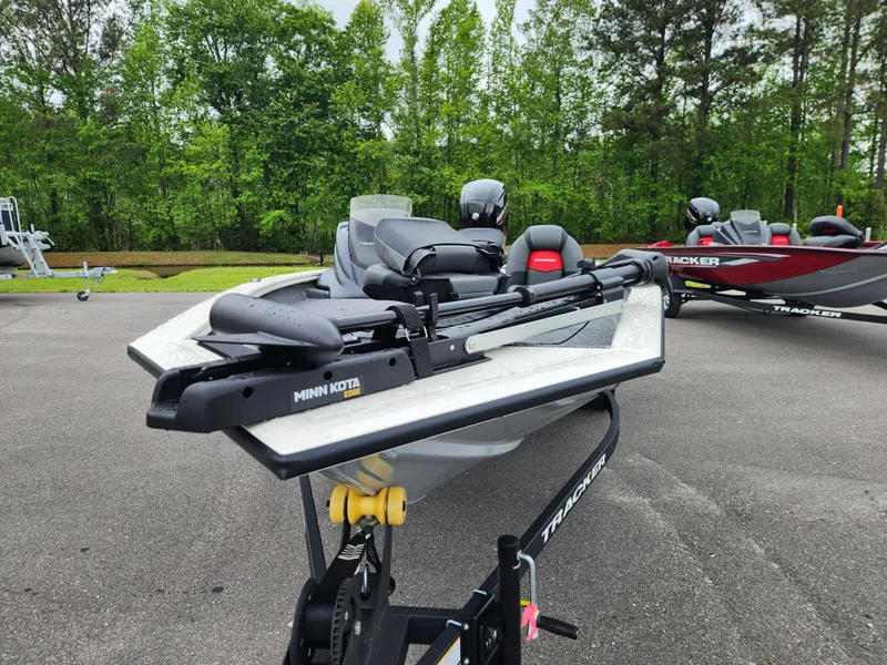 Slide: The Image of 2025 Tracker Pro Team 175 boat with Minn Kota motor, parked outdoors. - 7