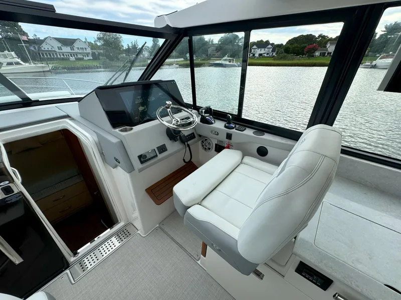 Slide: The Image of Helm of 2026 Regal 36 XO yacht with modern controls and waterfront view. - 24