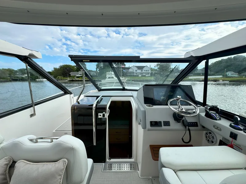 Slide: The Image of Interior view of 2026 Regal 36 XO yacht cockpit with steering wheel and navigation controls. - 29