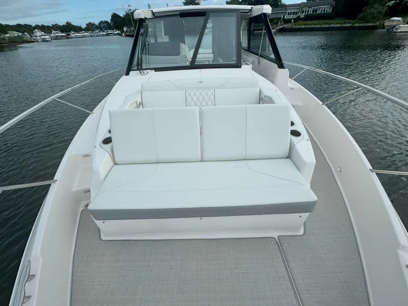 Slide: The Image of 2026 Regal 36 XO boat with white seating on a calm waterway. - 38