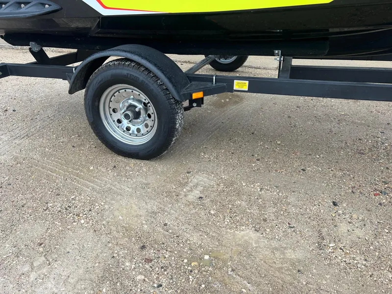 Slide: The Image of Trailer wheel of a 2014 Sea-Doo Wake Pro 215 on gravel surface. - 14