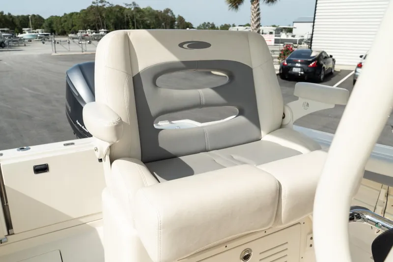 Slide: The Image of 2019 Cobia 240 Center Console boat seat, beige and gray, in a marina setting. - 4