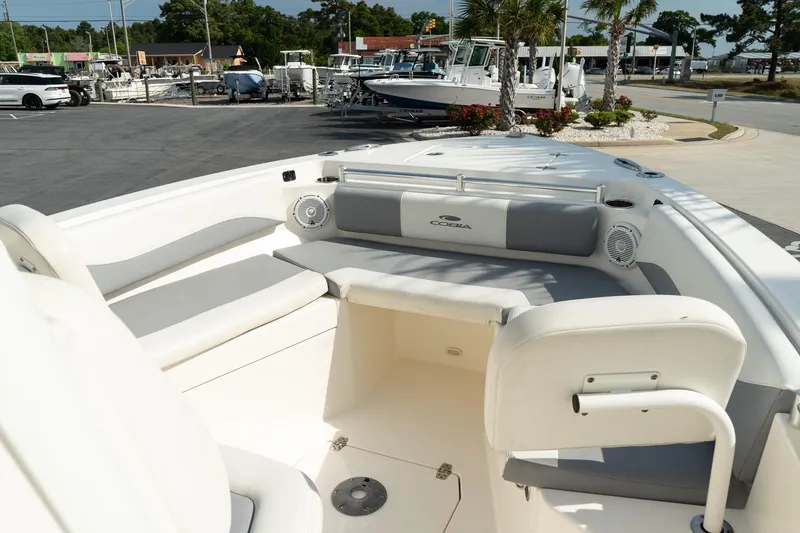 Slide: The Image of 2019 Cobia 240 Center Console boat interior with seating and speakers, docked at a marina. - 5