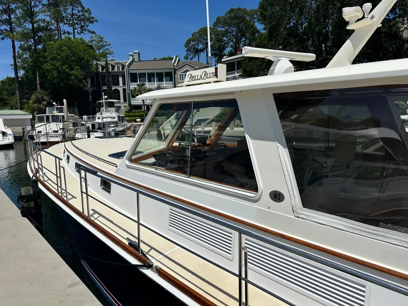 Slide: The Image of 2004 Grand Banks 49 Eastbay HX yacht docked at marina, surrounded by trees and buildings. - 11